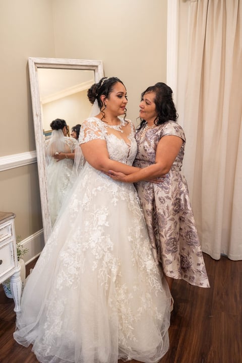 Bride hugging mother in bridal suite