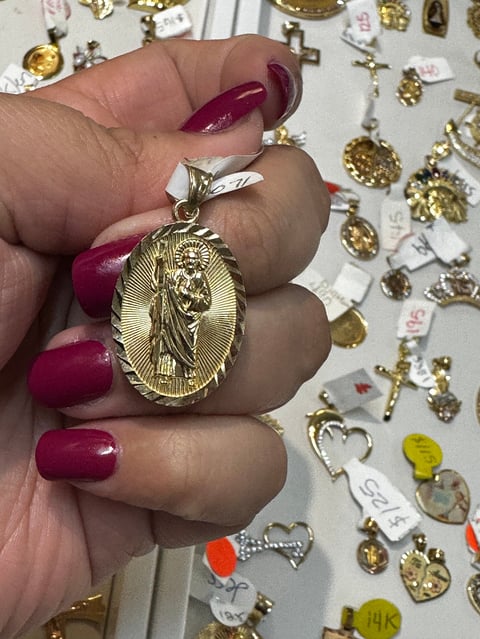 Gold religious medal with burgundy nails